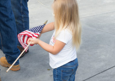 Child holding an American flag, Monument dedication Saturday, November 11, 2017